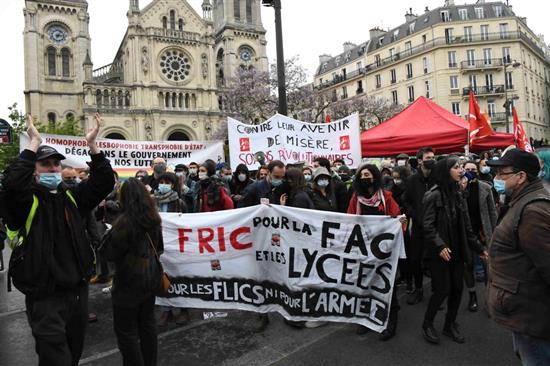 当地时间2021年5月1日，法国在新冠疫情中迎来“五一”劳动节大游行。法国官方通报全法10万人参加游行，其中巴黎有1.7万人参与。图为游行队伍中高举标语横幅的人士。